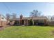 Back exterior view of the brick house highlighting the large, grassy backyard and fence at 7260 Marla Dr, Indianapolis, IN 46256