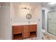 Bathroom featuring a wooden vanity with sink, round mirror, and walk-in shower at 7260 Marla Dr, Indianapolis, IN 46256