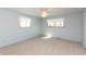 A bright bedroom with light blue walls, carpet, and natural light streaming through two windows at 7260 Marla Dr, Indianapolis, IN 46256