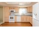 Bright kitchen featuring white appliances, wooden cabinets, and hardwood flooring at 7260 Marla Dr, Indianapolis, IN 46256