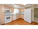 Well-lit kitchen with wooden cabinets, white appliances, and hardwood floors at 7260 Marla Dr, Indianapolis, IN 46256