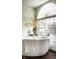 Bright bathroom features a soaking tub under an arched window with yellow flower decor at 8037 Lynch Ln, Indianapolis, IN 46250