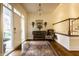 Elegant foyer featuring hardwood floors, a decorative rug, a wooden staircase, and stylish accent furniture at 8037 Lynch Ln, Indianapolis, IN 46250