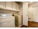 Well-lit laundry room with white cabinets and appliances at 8037 Lynch Ln, Indianapolis, IN 46250