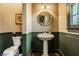Elegant powder room features a pedestal sink, decorative mirror, and sophisticated wainscoting at 8037 Lynch Ln, Indianapolis, IN 46250