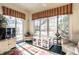 Bright sunroom with large windows, wicker furniture, striped valances, and tile flooring at 8037 Lynch Ln, Indianapolis, IN 46250