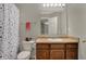 Well-lit bathroom featuring a vanity, toilet, mirror and patterned shower curtain at 8734 Blue Marlin Dr, Indianapolis, IN 46239