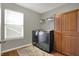A practical laundry room with modern appliances, cabinets, and a bright window at 8734 Blue Marlin Dr, Indianapolis, IN 46239