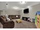 Relaxing living room with plush leather seating, a television, and play area at 8734 Blue Marlin Dr, Indianapolis, IN 46239