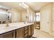 Bathroom featuring double sink vanity, dark wood cabinets, and a large mirror at 8855 Sugar Cay Ct, Zionsville, IN 46077