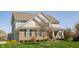 Inviting home with a manicured lawn, mature tree, and a partial view of the side garage, offering convenience at 8855 Sugar Cay Ct, Zionsville, IN 46077