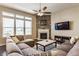 Inviting living room featuring a stone fireplace, large windows, and cozy sectional sofa, perfect for relaxation at 8855 Sugar Cay Ct, Zionsville, IN 46077