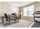 Comfortable office space with a large window, desk, and treadmill, providing a functional workspace at 8855 Sugar Cay Ct, Zionsville, IN 46077