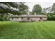 Expansive backyard featuring a brick home with a wooden deck, perfect for outdoor enjoyment and relaxation at 1000 Janet Dr, Greenwood, IN 46142