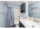 Bathroom featuring a sink, vanity, toilet, shower with curtain and dark cabinet above the toilet at 1000 Janet Dr, Greenwood, IN 46142