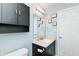 Bathroom featuring a sink, vanity, toilet, mirror and dark cabinet above the toilet with storage at 1000 Janet Dr, Greenwood, IN 46142
