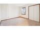 Bright bedroom featuring neutral carpet, trim, a window, and a double-door closet at 1012 S Montgomery Rd, Greenwood, IN 46143