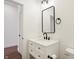 Modern bathroom with a white vanity, black fixtures, and a stylish rectangular mirror at 1018 Calvary St, Indianapolis, IN 46203