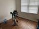 Spare bedroom features an exercise bike, hardwood floors, and natural light from the window at 1018 E 106Th St, Indianapolis, IN 46280