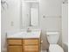 Neutral bathroom with a wood cabinet, white sink, commode, and large mirror at 10303 Memorial Knoll Dr, Indianapolis, IN 46234