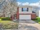 Beautiful two-story home featuring brick facade and attached two-car garage and lovely flowering tree at 10303 Memorial Knoll Dr, Indianapolis, IN 46234