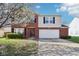Charming two-story brick and siding home featuring a two-car garage and blooming trees at 10303 Memorial Knoll Dr, Indianapolis, IN 46234