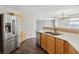 Kitchen with stainless appliances, white countertops and maple cabinets plus open access to living area at 10303 Memorial Knoll Dr, Indianapolis, IN 46234