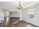 Spacious and airy living room featuring neutral paint, hardwood floors, a large window, and an elegant chandelier at 10303 Memorial Knoll Dr, Indianapolis, IN 46234