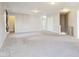 Spacious living room featuring neutral paint, modern lighting, and soft carpeting at 10303 Memorial Knoll Dr, Indianapolis, IN 46234