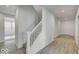 Bright hallway with white stairs, leading to the upper levels of the home and luxury vinyl flooring at 1056 Stubble Run, Danville, IN 46122