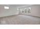 Bright living room with plush carpet, neutral walls, and large windows offering serene outdoor views at 1056 Stubble Run, Danville, IN 46122