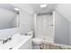 This bathroom offers a modern vanity, toilet, and a standing shower, all illuminated by a modern light fixture at 121 Illinois St, Shirley, IN 47384