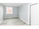 A bright bedroom with gray paint, vinyl flooring, a window, and a closet door at 121 Illinois St, Shirley, IN 47384