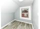 This bedroom features wood-look floors, light gray walls, and a window that brightens the space at 121 Illinois St, Shirley, IN 47384