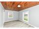 Bedroom with wood plank ceiling, gray walls, vinyl floor, and two windows for plenty of natural light at 121 Illinois St, Shirley, IN 47384