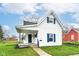 Charming home featuring white siding, blue shutters and door, and a well-maintained front lawn at 121 Illinois St, Shirley, IN 47384