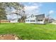 Exterior view of home with large lawn, mature trees and landscaping, including detached garage at 121 Illinois St, Shirley, IN 47384