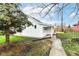 Exterior shot of home featuring white siding, a small patio, and a narrow walkway to the backyard at 121 Illinois St, Shirley, IN 47384