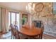 Dining area with chandelier, wooden table, large window and stone fireplace at 12166 N Bray Rd, Mooresville, IN 46158