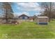 Large backyard featuring a chicken coop, greenhouse and expansive lawn at 12166 N Bray Rd, Mooresville, IN 46158