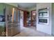 View of stainless steel fridge, brick oven area and dining area, creating an open and inviting kitchen design at 12166 N Bray Rd, Mooresville, IN 46158