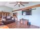 Spacious living room with hardwood floors, ceiling fan, and large television provides comfortable living space at 12166 N Bray Rd, Mooresville, IN 46158