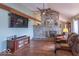 Comfortable living room featuring leather reclining chairs, stone fireplace, hardwood floors, and large tv at 12166 N Bray Rd, Mooresville, IN 46158