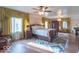 Bright main bedroom features a large window, beautiful rug, and a decorative ceiling fan with lighting at 12166 N Bray Rd, Mooresville, IN 46158