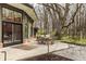 Backyard patio with table and seating surrounded by mature trees, offering a tranquil outdoor space at 123 W 81St St, Indianapolis, IN 46260