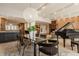 An open-concept space features a glass dining table, a piano, and wood floors at 123 W 81St St, Indianapolis, IN 46260