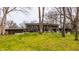 Modern home with a green lawn, multiple windows, mature trees, and a patio with outdoor seating at 123 W 81St St, Indianapolis, IN 46260