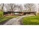 Charming single-story brick home featuring a well-maintained lawn and mature trees, offering curb appeal at 123 W 81St St, Indianapolis, IN 46260