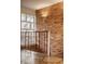 Staircase with a decorative window, brick wall, patterned flooring, and an ornamental metal railing at 123 W 81St St, Indianapolis, IN 46260