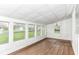 Bright sunroom with wood floors and multiple windows offering scenic outdoor views at 1254 E 400 N, Greenfield, IN 46140